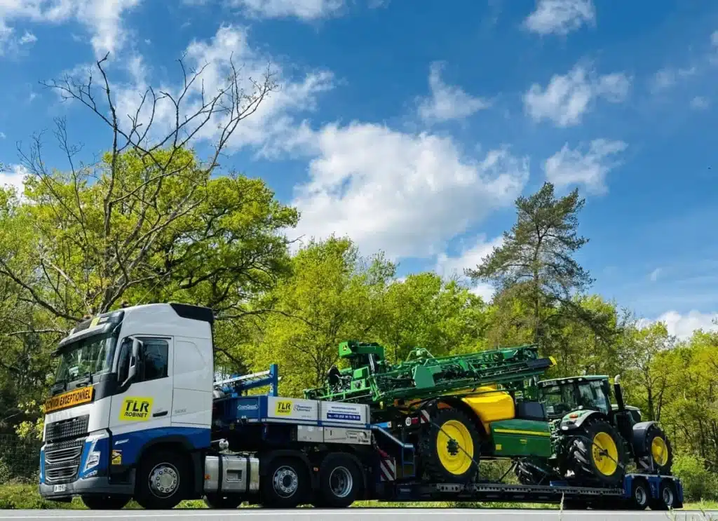 Camion de chez TLR en train de transporter un tracteur